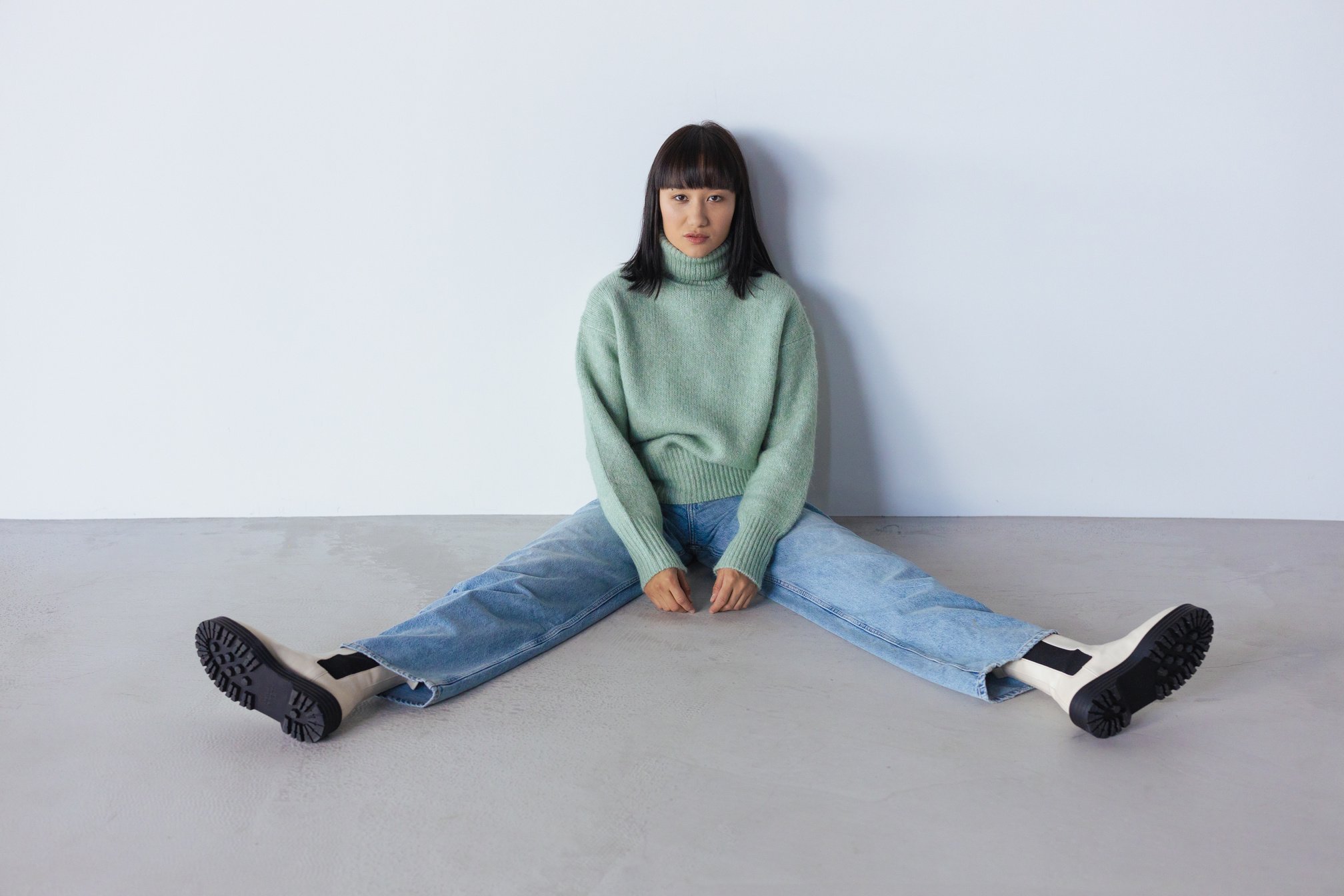 Woman in Green Sweater Sitting on the Floor